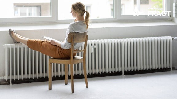 Eine Frau sitzt an einem Fenster.