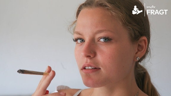Junge Frau raucht Cannabis in einem Joint