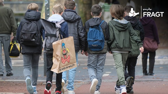 Eine Gruppe Kinder gehen über eine Straße.