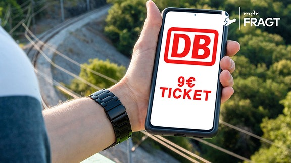 Mann verwendet auf einer Reise sein Smartphone und zeigt auf dem Bildschirm das Neun Euro Ticket.