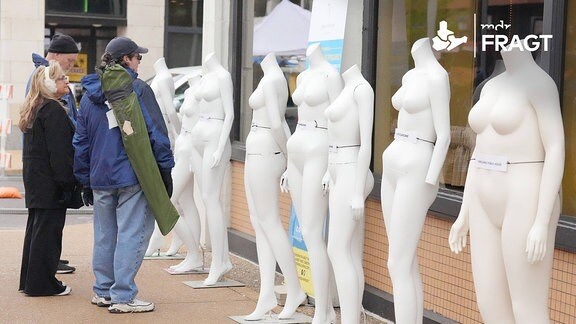 Menschen schauen sich Schaufensterpuppen an