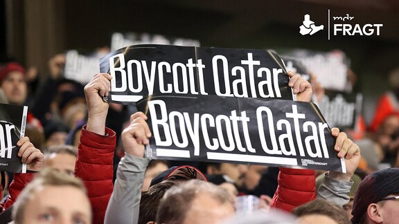 Fans des SC Freiburg halten Plakate mit der Aufschrift "Boycott Qatar".