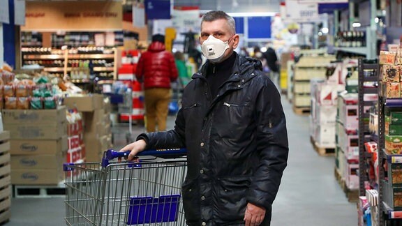 Ein Mann mit einem Mundschutz in einem Supermarkt