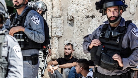 Israelische Polizisten und festgenommene Palästinensern nach Zusammenstößen auf dem Tempelberg in Jerusalem
