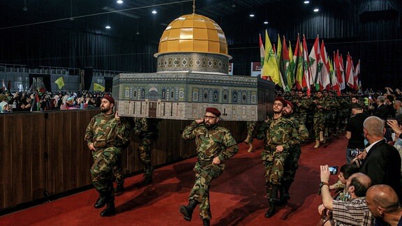 Kämpfer der Hisbollah tragen während einer Kundgebung zum Al-Kuds-Tag - Kuds ist der arabische Name für Jerusalem - eine Nachbildung des Felsendoms.