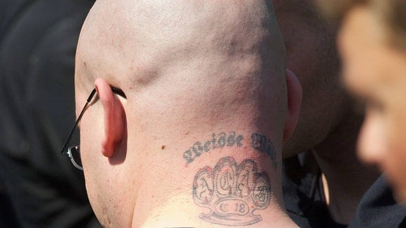 Ein Neoanzi-Skinhead mit einem Tattoo der rechtsradikalen Nazi-Organisation Weisse Wölfe und einem Schlagring mit dem Kuerzel C18,  2012