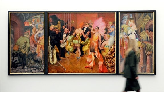 Eine Frau geht an dem Triptychon "Großstadt" von Otto Dix vorbei