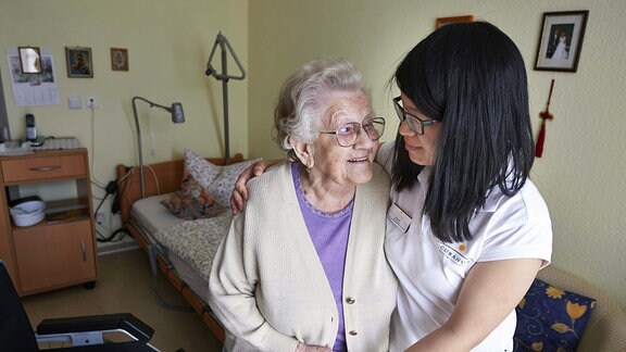 Die Altenpflegerin Song Xi aus China betreut die 96-jährige Luise Heise auf ihrem Zimmer.