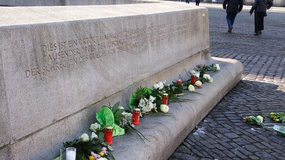 Blumen und Grablichter an einer Gedenkstelle in Dresden