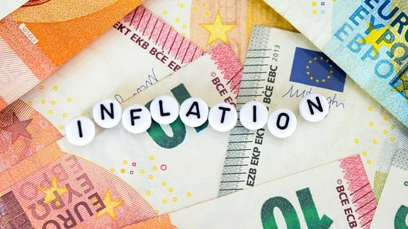 Symbolfoto Inflation Inflationsrate mit Geldscheinen und Geldmuentzen im Hintergrund
