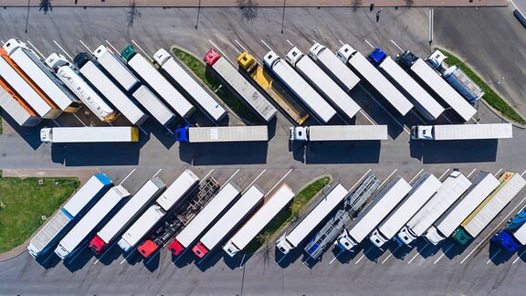 Lastwagen auf dem Parkplatz einer Autobahnraststätte aus der Vogelperspektive