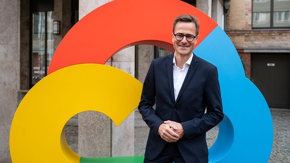Philipp Justus, Vize Präsident von Google Zentraleuropa steht für ein Foto vor einem Firmenlogo.
