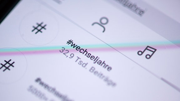 Auf dem Bildschirm eines Smartphones steht der Hashtag #wechseljahre in der App Instagram.