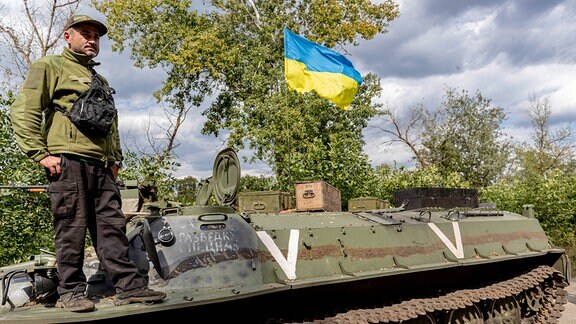 Ukrainischer Soldat auf verlassenem russischen Panzer.