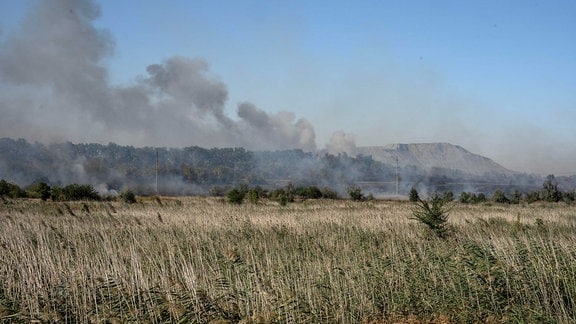 Nach einem Raketeneinschlag zeigt sich auf einem Feld schwarzer Rauch