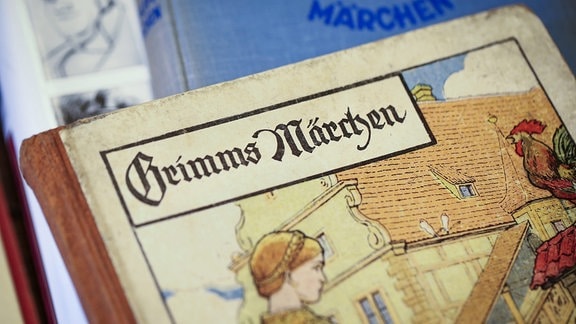 Ein Buch mit dem Titel "Grimms Märchen" ist halb zu sehen.