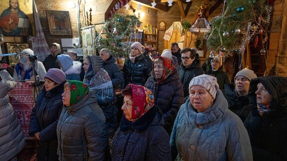 Menschen beten während des Weihnachtsgottesdienstes in einer Kirche im Dorf Pirogovo außerhalb der Hauptstadt Kiew.