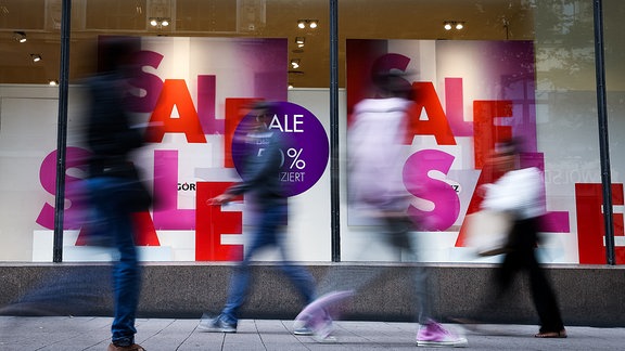 Schilder mit der Aufschrift "Sale" in einem Schaufenster