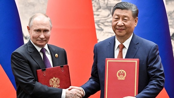 Russlands Präsident Wladimir Putin und der chinesische Staats- und Parteichef Xi Jinping beim Händeschütteln