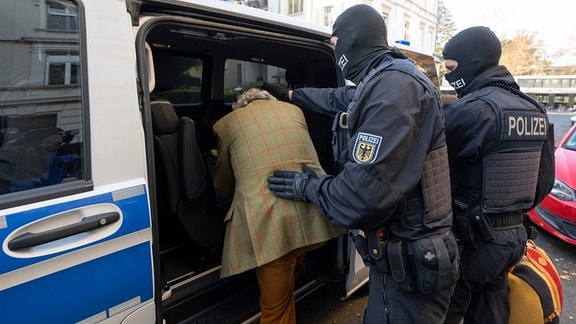 Bei einer Razzia gegen sogenannte «Reichsbürger» führen vermummte Polizisten, nach der Durchsuchung eines Hauses Heinrich XIII Prinz Reuß zu einem Polizeifahrzeug