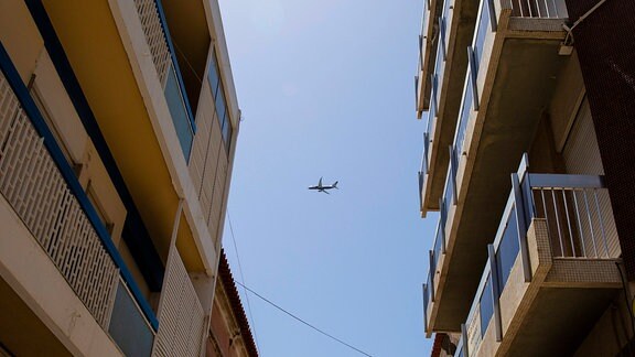 Flugzeug startet und fliegt über eine Wohnsiedlung.