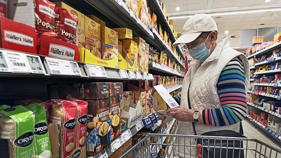 Ein Rentner beim Einkauf in einem Supermarkt oder Discounter zu Zeiten von Corona und Krieg in der Ukraine. 