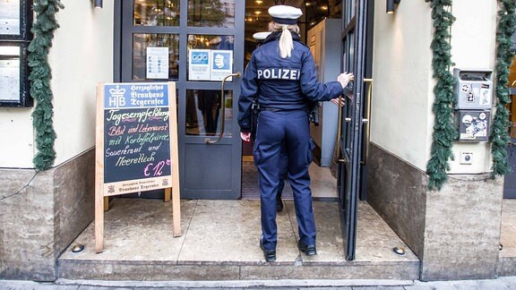 Eine Polizistin betritt ein Restaurant