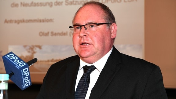 Olaf Sendel, Landesvorsitzender der DPolG Sachsen-Anhalt spricht in eine Mikrofon