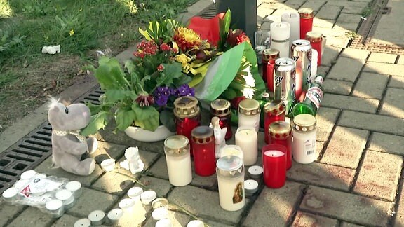 Mehrere Kerzen stehen auf einem Bahnsteig