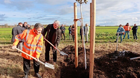 Umweltminister Armin Willingmann (2.v.l.) und Infrastrukturministerin Lydia Hüskens (l.), haben gemeinsam zum Abschluss einer Pflanzaktion in Ohrsleben einen Apfelbaum gepflanzt.