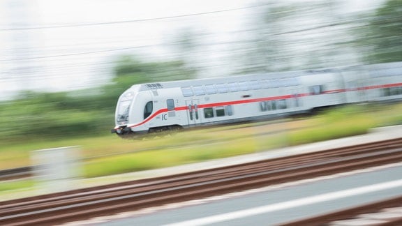 Ein doppelstöckiger Intercity 2 (IC2) fährt über Schienen. 