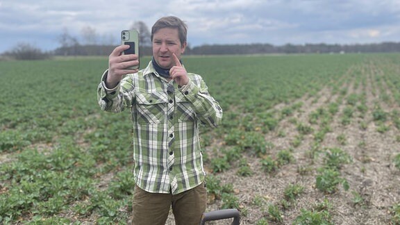 Farmfluencer Michel Allmrodt filmt sich auf eienm Feld.