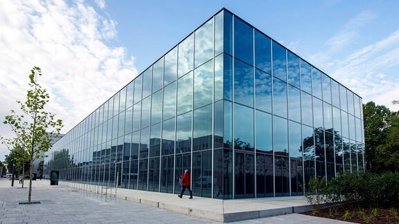 Wolken spiegeln sich in der gläsernen Fassade des Bauhaus Museums in Dessau.