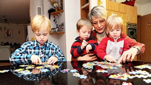 Familienpatin Ruth Friedrich spielt mit Luca Pascal (5 Jahre, re.) und den dreijährigen Zwillingen Marc-Leon (li), Julien-Marcel (Mitte).