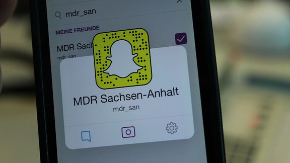 Zu sehen ist ein Smartphone, auf dessen Bildschirm in einer geöffneten Applikation der Auftritt von MDR SACHSEN-ANHALT erscheint
