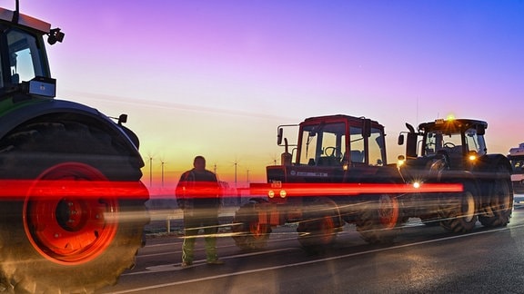 Landwirte blockieren am frühen Morgen mit ihren Fahrzeugen die Auffahrt auf die Autobahn A12