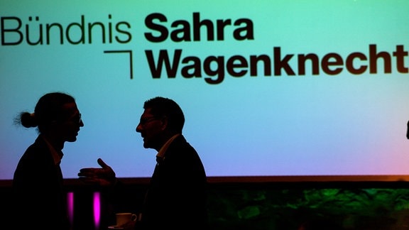 John Lucas Dittrich (l) von der Partei Bündnis Sahra Wagenknecht (BSW) und Thomas Schulze (BSW) stehen auf dem Gründungsparteitag des BSW Sachsen-Anhalt vor einer Leinwand, auf der der Parteiname projiziert ist.