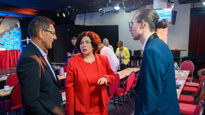 Thomas Schulze (l-r), Co-Landesvorsitzender der Partei "Bündnis Sahra Wagenknecht" (BSW), Amira Mohamed Ali, Vorsitzende der Partei BSW und John Lucas Dittrich, Co-Landesvorsitzender vom BSW sprechen nach dem Gründungsparteitag miteinander. | Bildrechte: picture alliance/dpa | Klaus-Dietmar Gabbert Thomas Schulze (l-r), Co-Landesvorsitzender der Partei "Bündnis Sahra Wagenknecht" (BSW), Amira Mohamed Ali, Vorsitzende der Partei BSW und John Lucas Dittrich, Co-Landesvorsitzender vom BSW sprechen nach dem Gründungsparteitag miteinander.