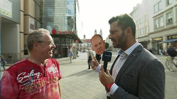 MDR Reporter Stefan Bernschein mit Olaf-Scholz-Maske im Gespräch mit einem Passanten