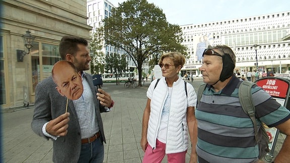 MDR Reporter Stefan Bernschein mit Olaf-Scholz-Maske im Gespräch mit einem Passanten
