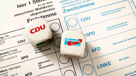 Stimmzettel zur Bundestagswahl, auf dem 2 Würfel liegen, CDU und AfD