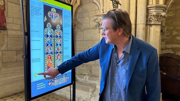  Museumsdirektor Christian Juranek präsentiert ein digitales Kirchenfenster im Schloss Wernigerode.