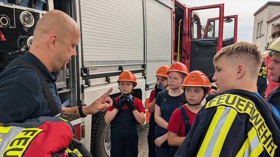 Kinder stehen vor einem Feuerwehrauto