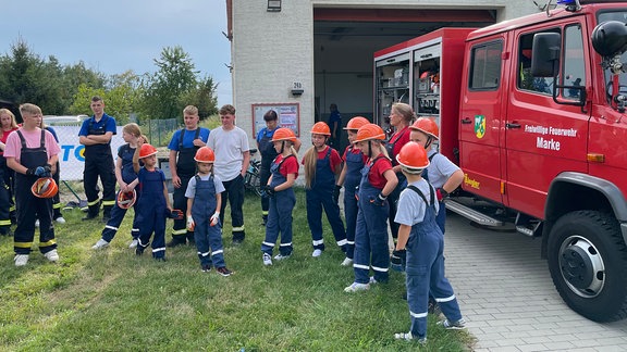 Kinder stehen vor einem Feuerwehrauto