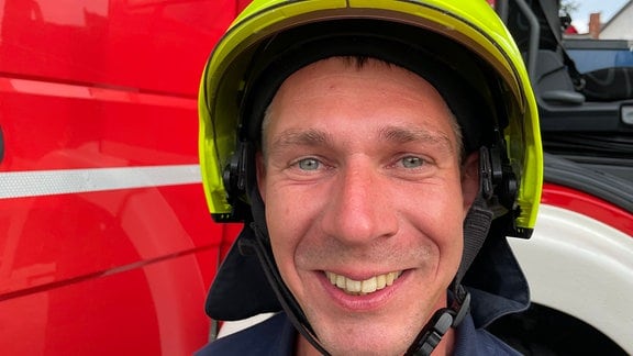 Stadtjugendwart Christian Sänger in Feuerwehruniform vor einem Feuerwehrauto