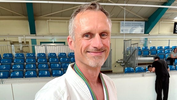 Thomas Gelbrich im Karate-Anzug mit einer Medaille um den Hals