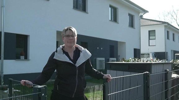 Manuela Liebich steht am Tor zu ihrem Grundstück im Wohngebiet "Zur Luther Linde" in Muldenstein.