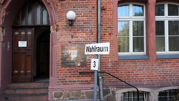 Eingang der Stadtverwaltung von Bittefeld-Wolfen. Davor steht ein Hinweisschild mit der Aufschrift "Wahlraum 3".
