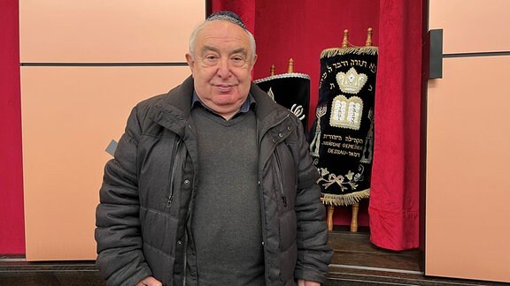 Ein Mann mit Kippa steht in einer Synagoge.