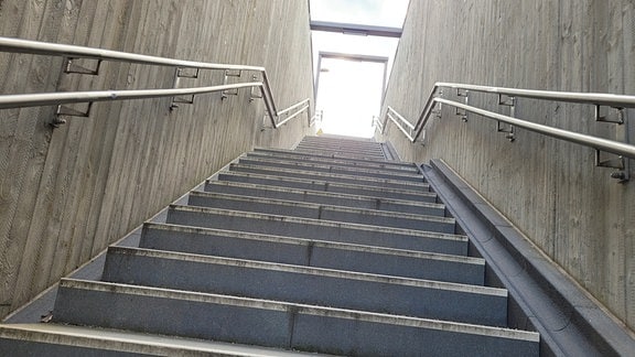 Eine steile Treppe am Bahnhof Meinsdorf von unten.